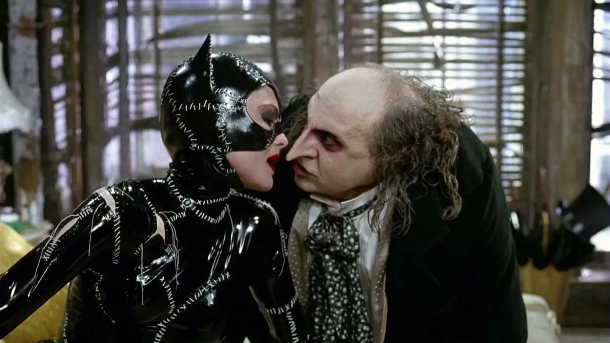 Catwoman and the Penguin sit on a bed and talk in Tim Burton's Batman Returns