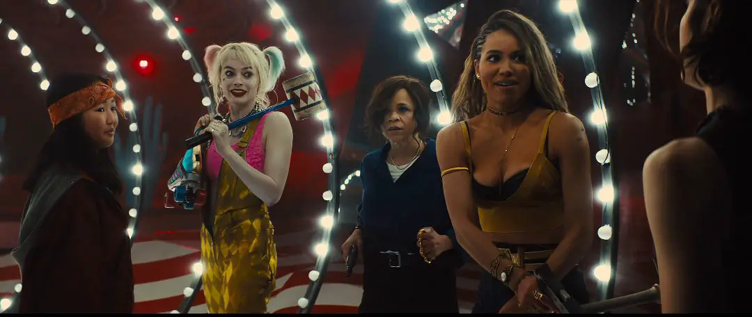 Harley Quinn and the others in a hall with lights running up the walls