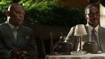 Samuel L Jackson and Anthony Mackie sit at a table in The Banker