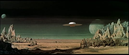 Flying saucer drifts over an alien desert