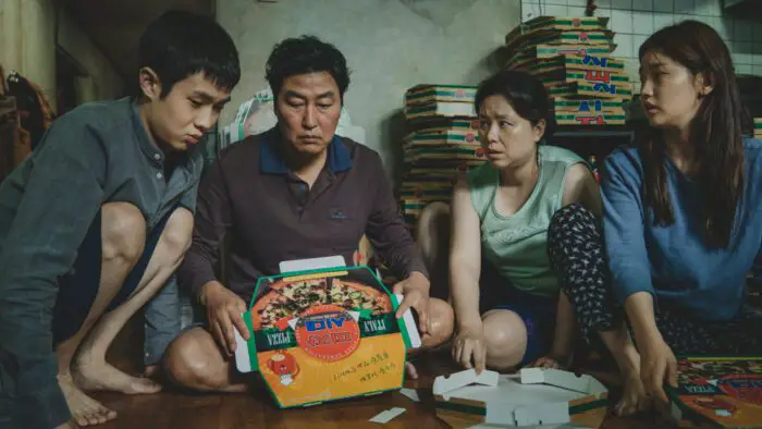 A South Korean family unfolds a pizza box in their living room
