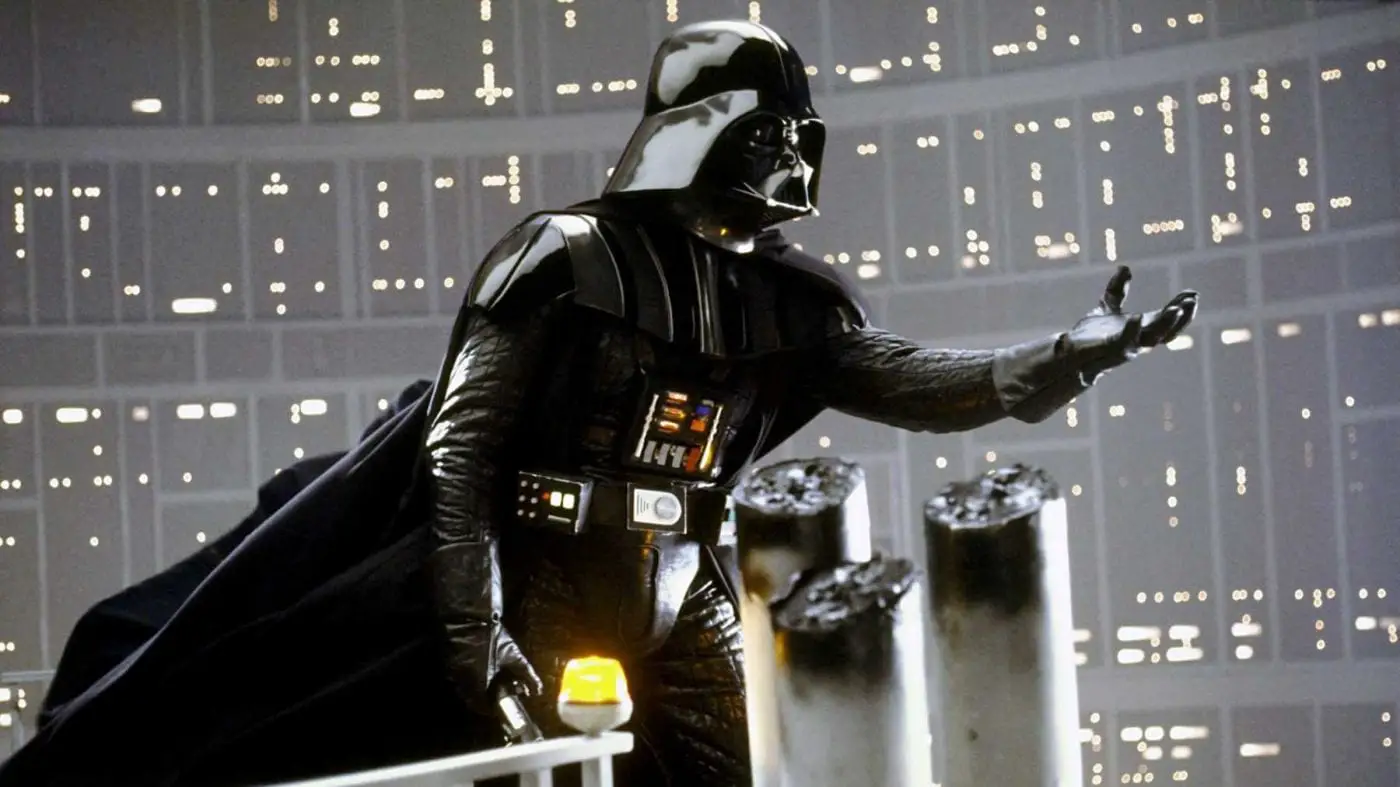 Darth Vader stading at the edge of a platform, holding out his hand