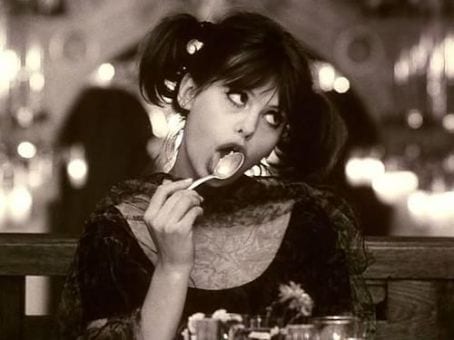 Marie I licks a spoon seductively at a restaurant