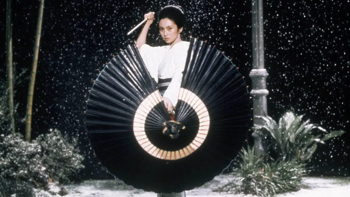 Yuki stands behind an umbrella she uses as a shield and holds her katana high