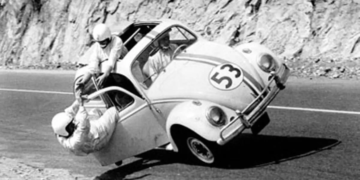 The Love Bug black and white photo of Herbie on two wheels with Michele Lee holding onto Buddy Hackett who's hanging outside the door while Jim drives