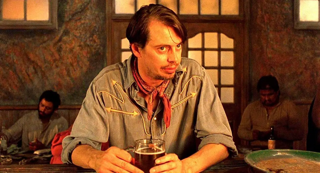 Buscemi leans in to tell a story to a bartender in "Desperado"
