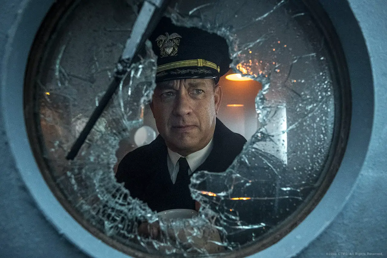 Tom Hanks looks out a damaged porthole on a battleship