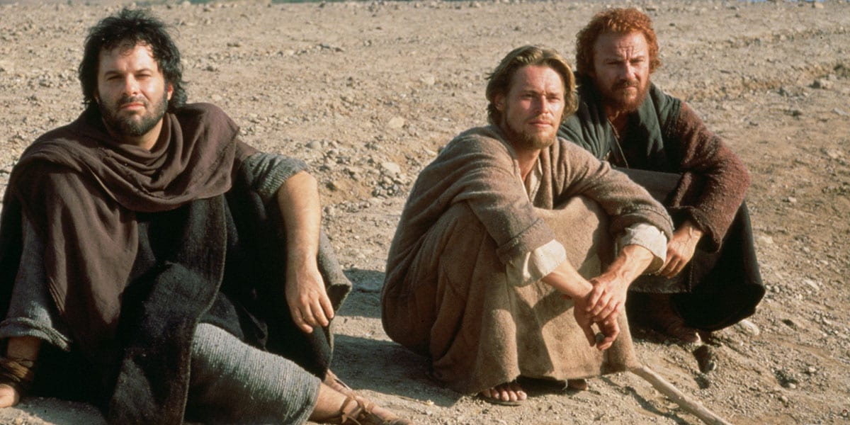 Jesus sitting in the sand with John and Judas on either side of him