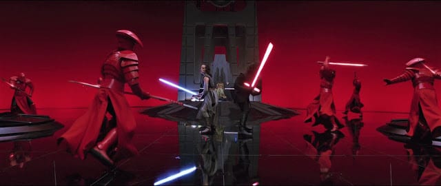 Rey and Kylo Ren fight a bunch of guys in red armor in a throne room.