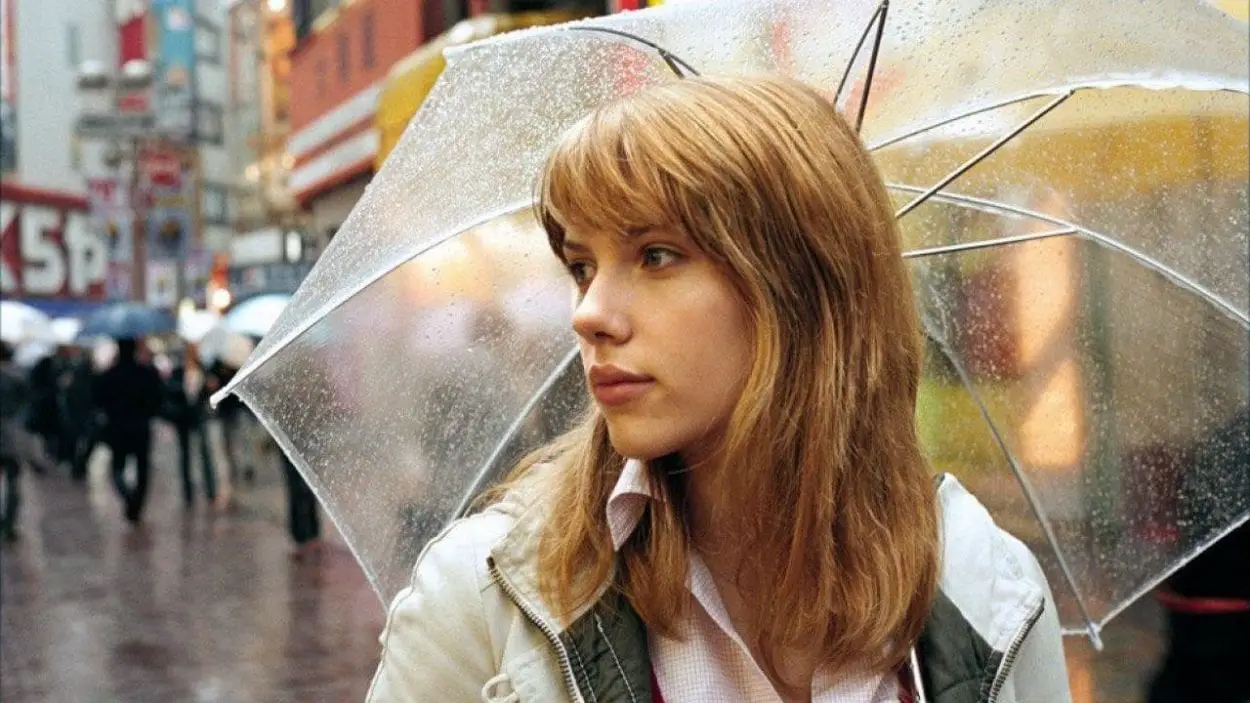 Charlotte walks through Tokyo with a translucent umbrella