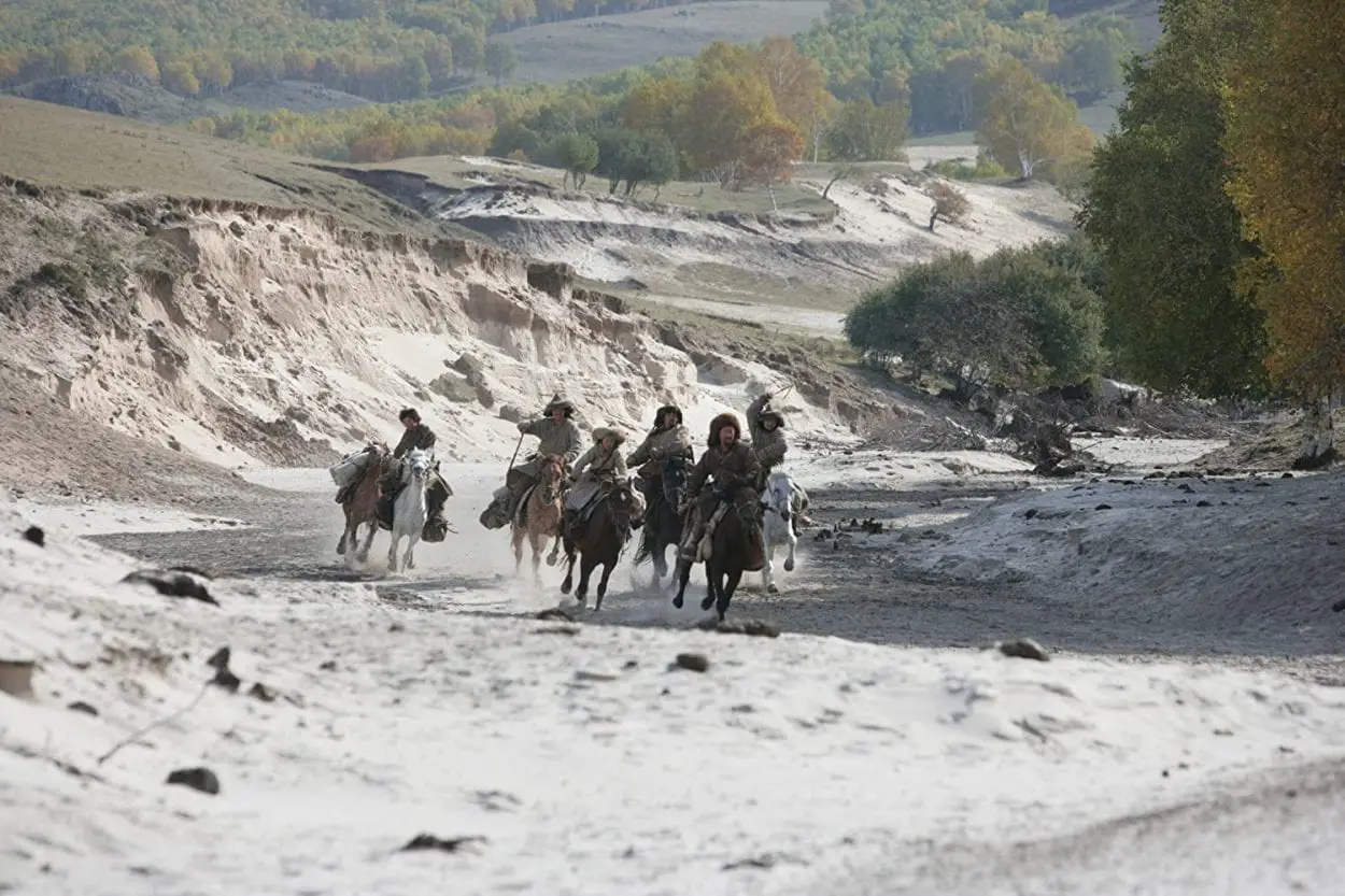 Temudjin leads a small group of Mongols, riding on horseback through the snow covered Mongolian Steppes