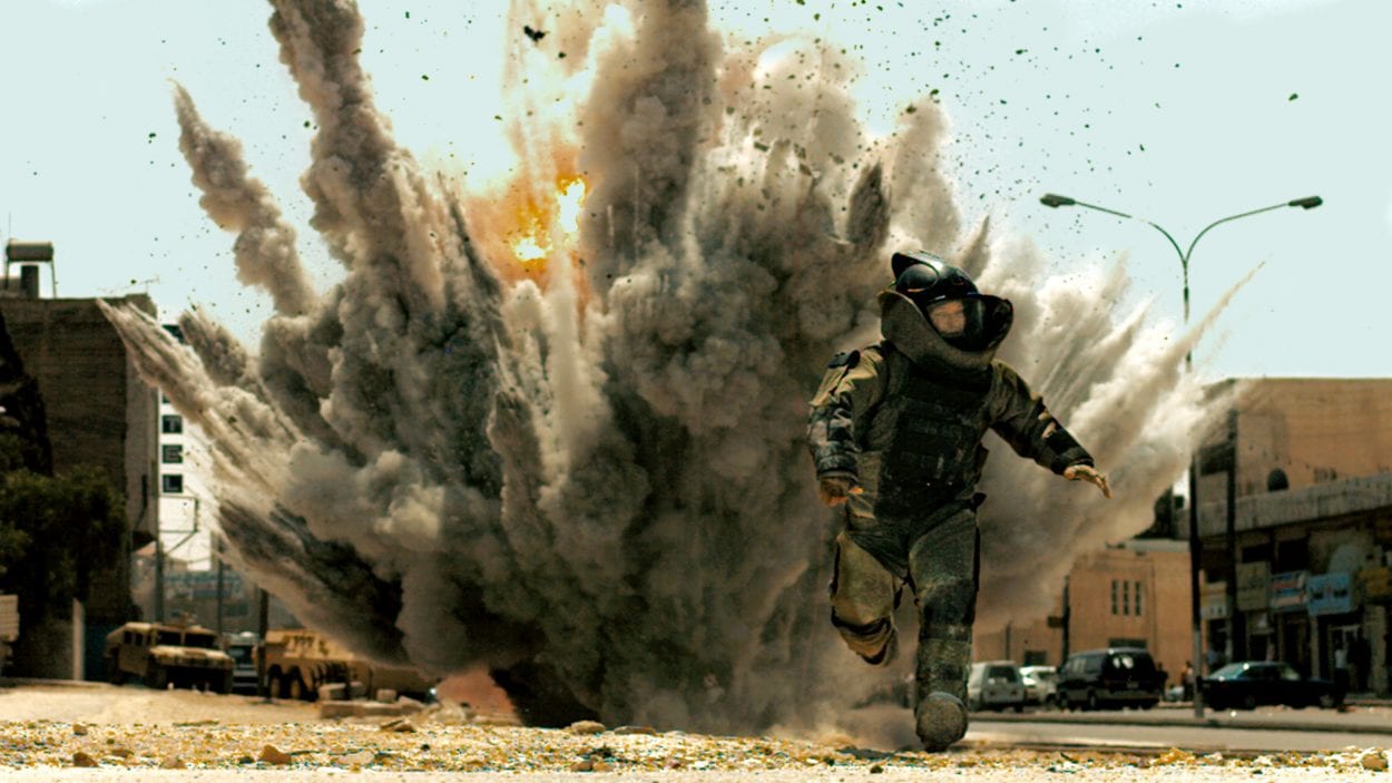 a bomb technician in the bomb suit running from an explosion