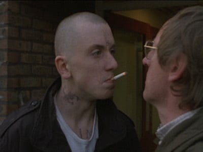 Trevor blows cigarette smoke in Peter's face