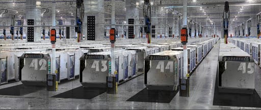 A large warehouse with numbered pods spread throughout.