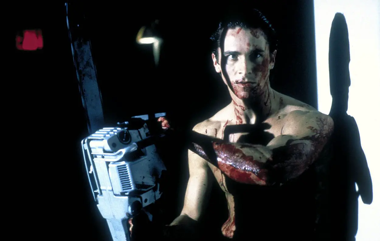 Bateman covered in blood, holding a chainsaw.