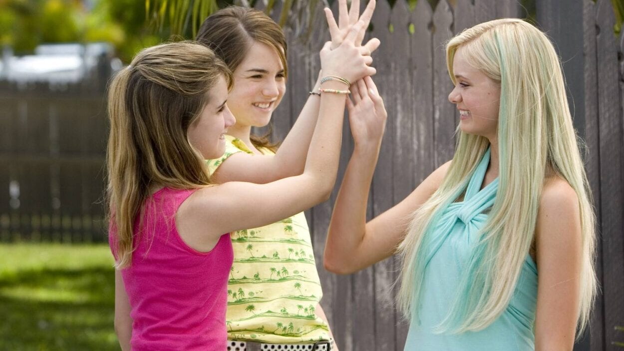 Claire, Hailey and Aquamarine join hands and smile