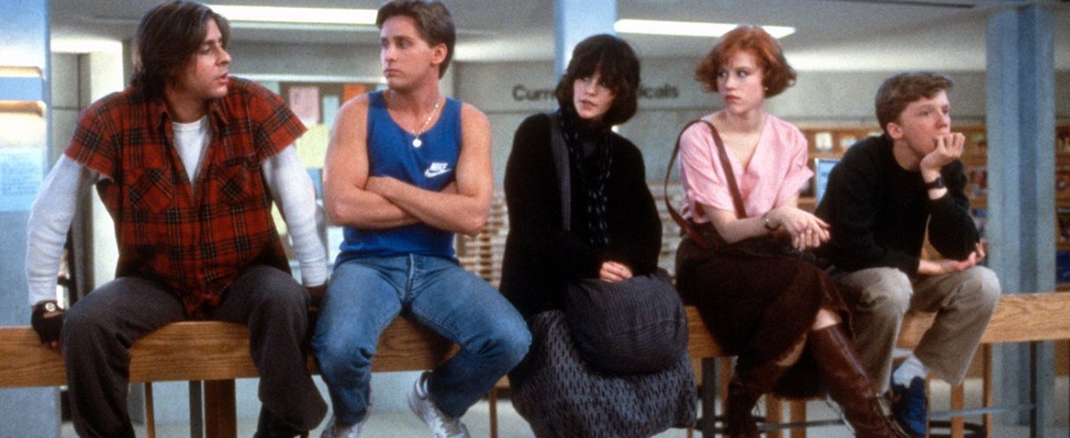 The Cast of the Breakfast Club sitting on a railing looking at one another