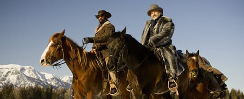 Django and Dr. King Shultz ride on horseback side by side.