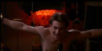 Shirtless Christian Slater yelling into a microphone