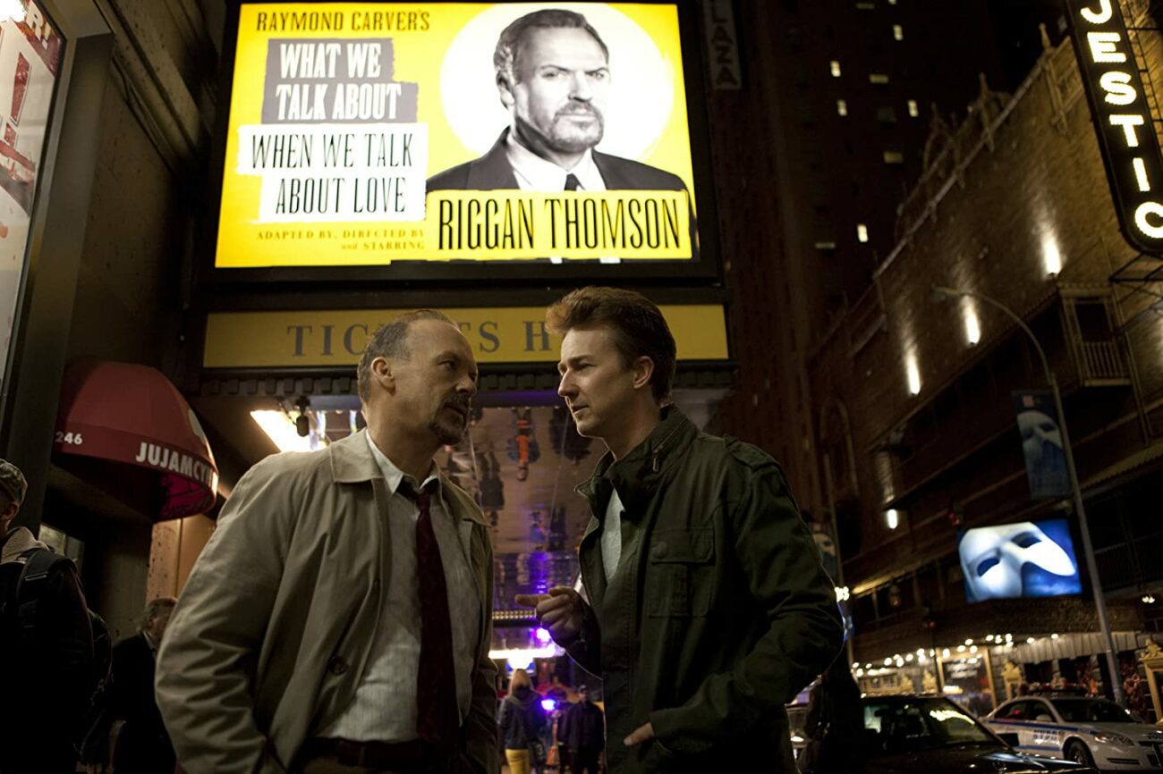 Riggan and Mike talk on the street beneath a theatre marquee.