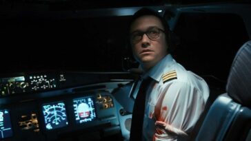 Co-pilot Tobias Ellis looks backward to the seating area monitor in distress from his cockpit seat.
