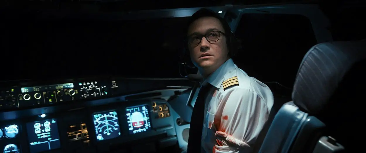 Co-pilot Tobias Ellis looks backward to the seating area monitor in distress from his cockpit seat.