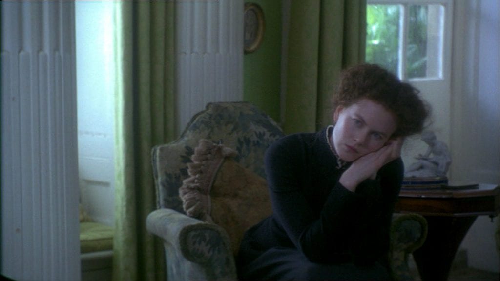 Isabel Archer (Nicole Kidman) sits in a chair, leaning on her hands in The Portrait of a Lady