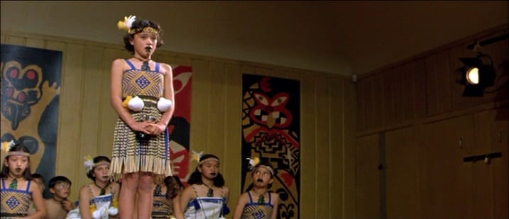 Paikea is standing on a stage with her classmates behind her, they are all dressed in tribal clothing