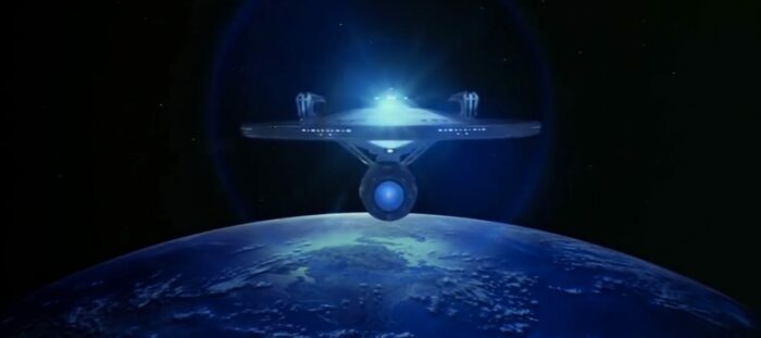 The starship Enterprise flies above Earth