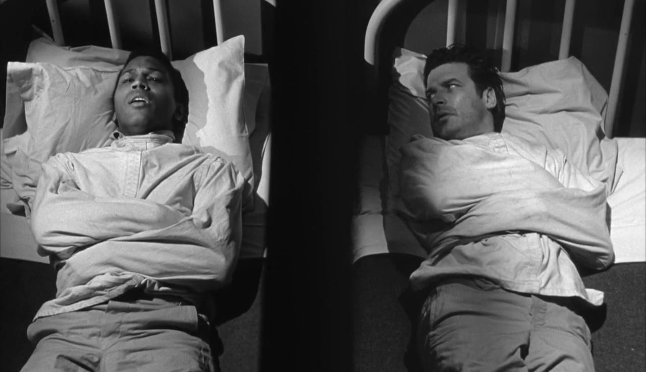 A straitjacketed Trent and Johnny lie in adjacent hospital beds