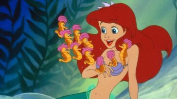 Ariel happily watches a bunch of seahorses swimming around her