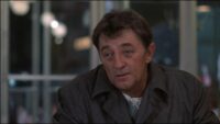 Eddie Coyle (Robert Mitchum) talks with an offscreen Jackie Brown (Steven Keats) at a table