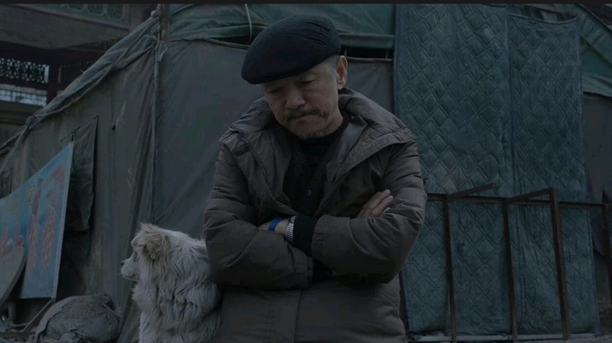 Wang Jin (Zi Xi) sits outside arms-crossed with his dog at his side