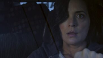 Jessica (Jules Wilcox) driving her car, appearing shocked.