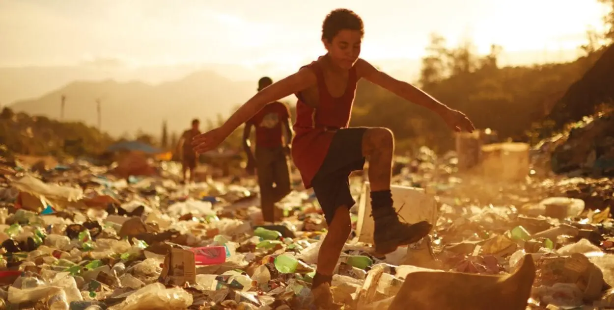Raphael dances in the garbage pile as Gardo runs over to him.