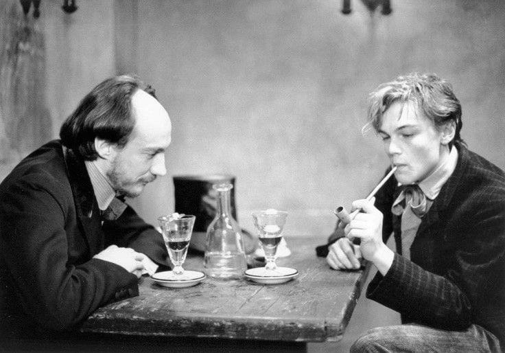Arthur Rimbaud and his mentor and lover Paul Verlaine sit across a table from one another