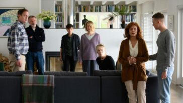 Lily's family and friends gather in surprise to a revelation from Jennifer in a living room.