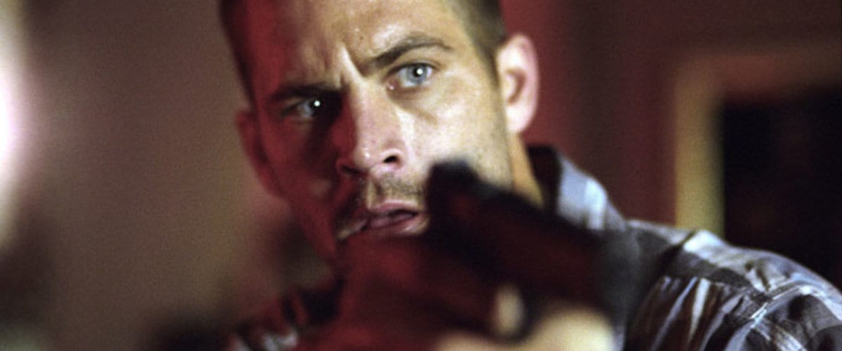Paul Walker holding a gun as the on edge main character in Running Scared.