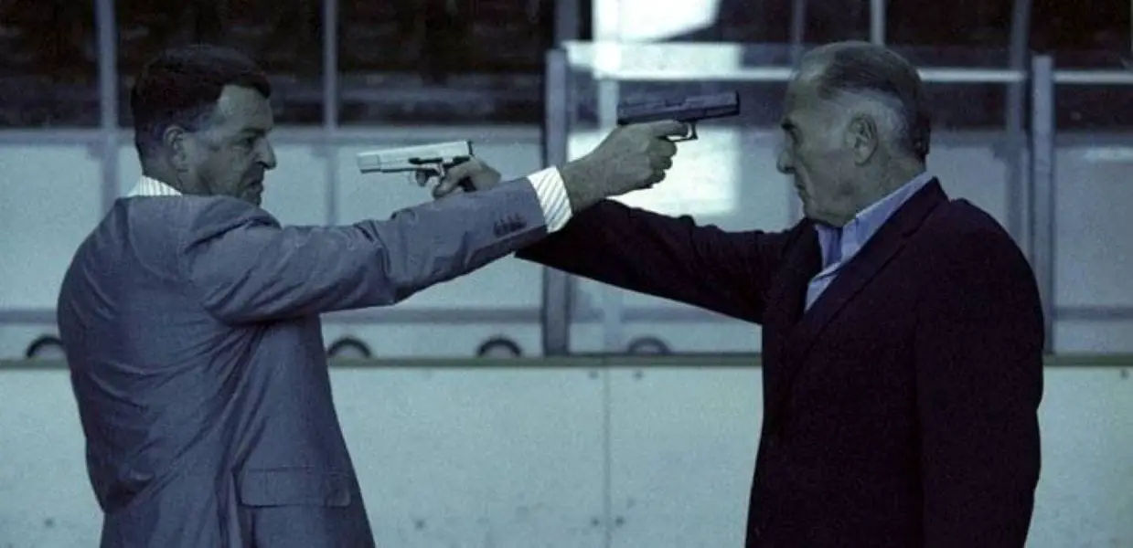 The Italian and Russian mafia bosses point guns at each other in an ice rink in the climax of Running Scared.