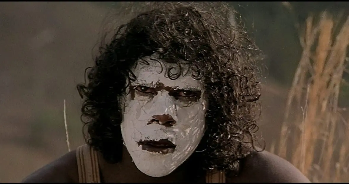 Mort Blacksmith (Freddy Reynolds) stares into the camera with an absent stare while wearing white facepaint.