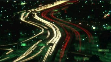 A long-take shot of a freeway with speeding cars being shown in lines of lights