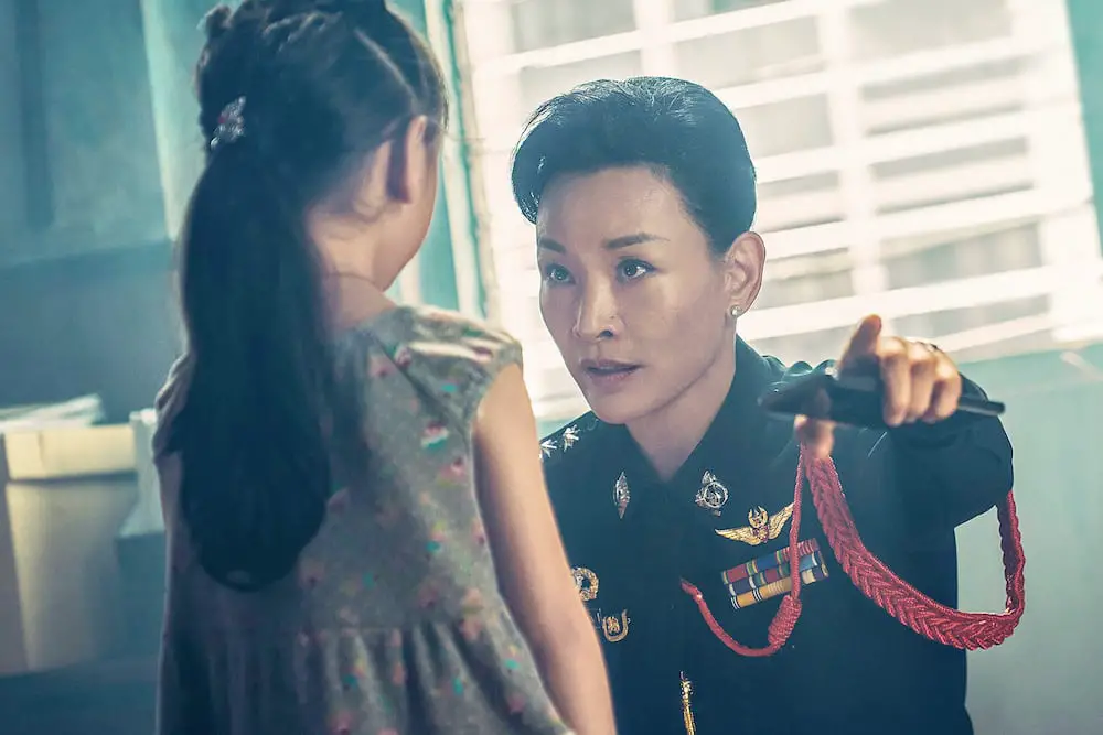 Laoorn (Joan Chen), chief of police, interrogates the child An'An (Xirang Zhang) in a police station.