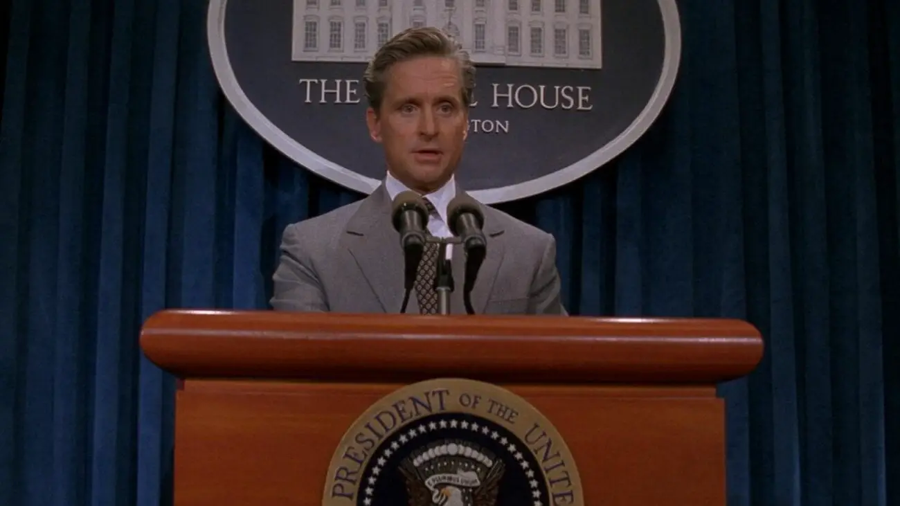 President Shepherd stands at a podium speaking to the White House press corps.