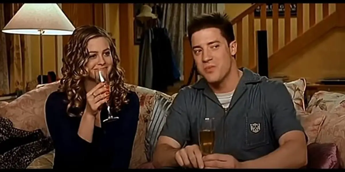 Brendan Fraser and Alicia Silverstone in Blast from the Past, sitting on a couch together and drinking from wine glasses