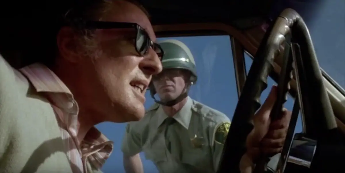 A dying driver of a mysterious car is confronted by a highway patrolman in Repo Man 