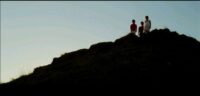 A low-angle shot of Eliza (Angeli Bayani) and her children JR (AJ Baliat) and Sarah (Aneeza Hernandez) looking down from a cliff