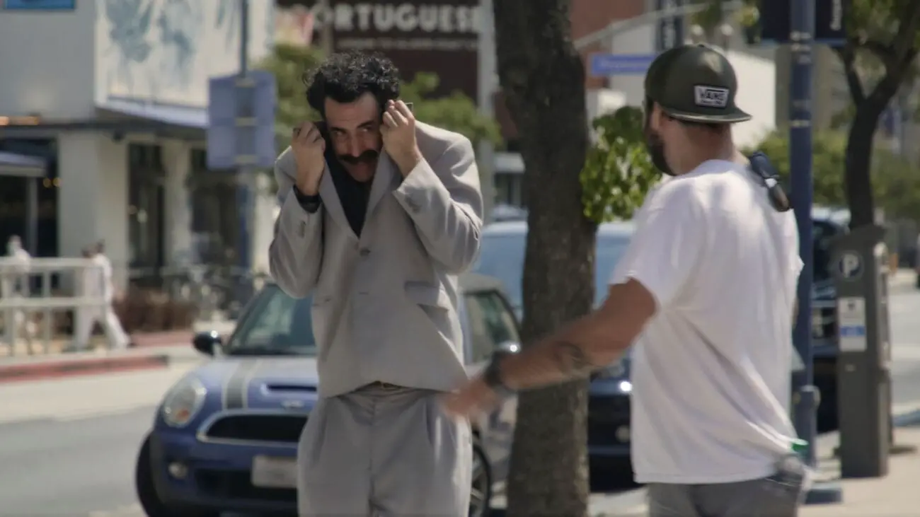 Borat hides in his suitcoat from someone who recognizes him.