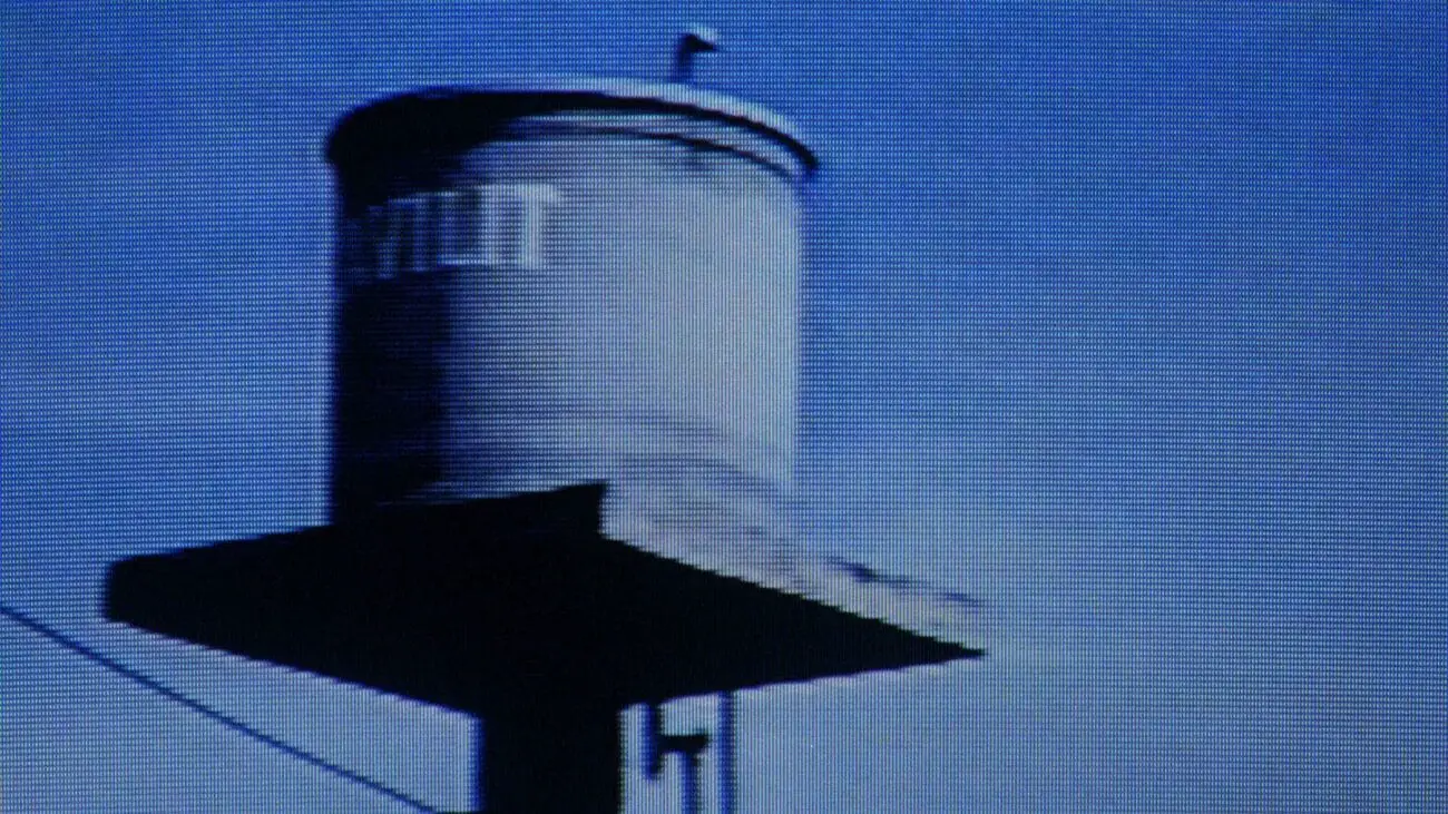 A medium shot of news coverage focusing on a water tower displayed on a television screen.