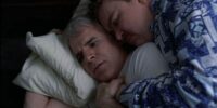 Neal and Del, cuddled together in bed, Neal slightly awake and instantly horrified in Planes, Trains and Automobiles