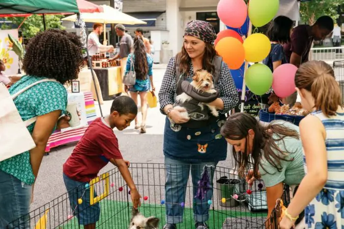 Carol works at dog adoption event with young children.